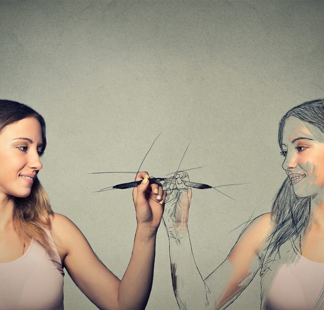Woman holding a marker draws her image on a mirror